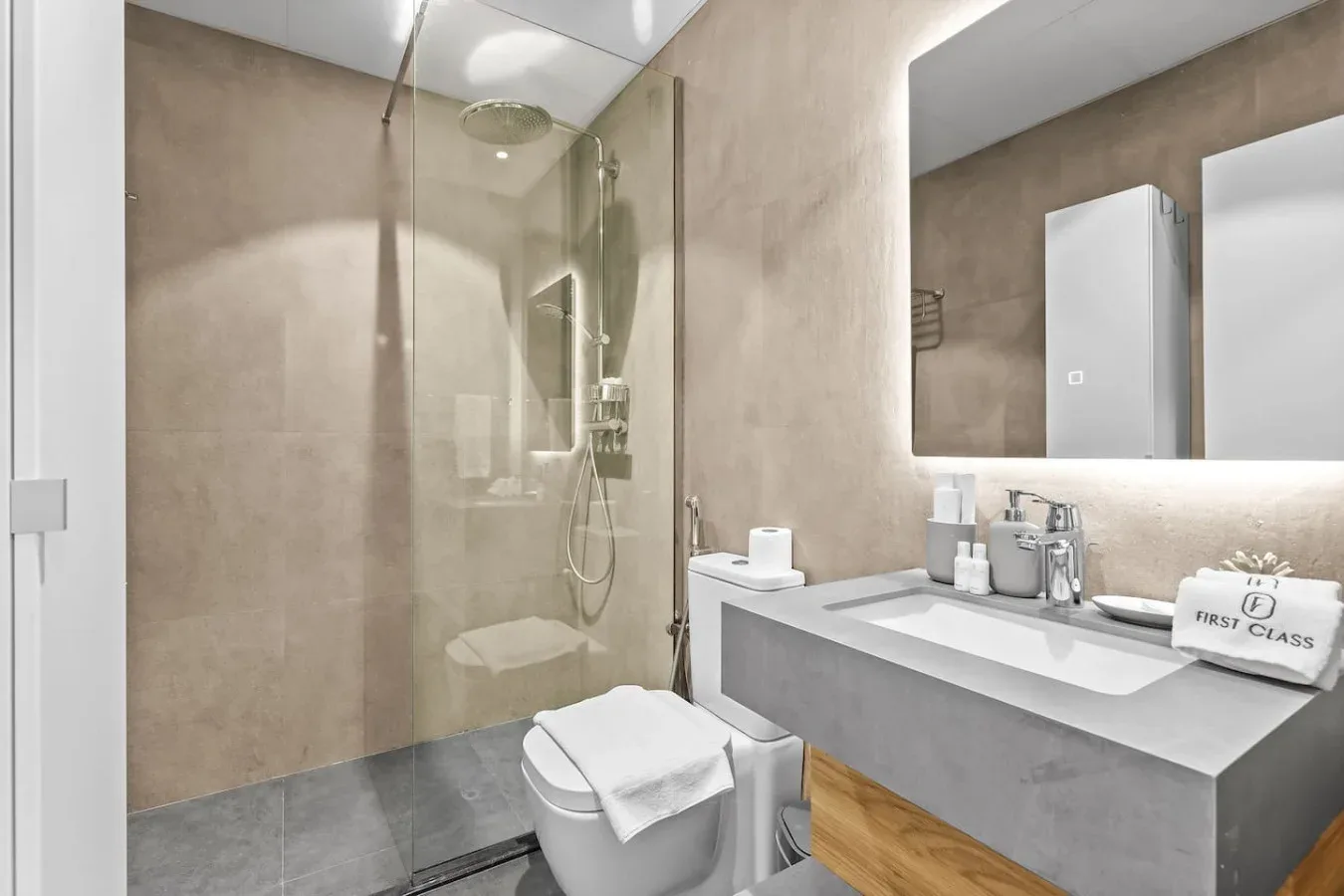 Un baño moderno con una ducha de vidrio y un lavabo amplio.