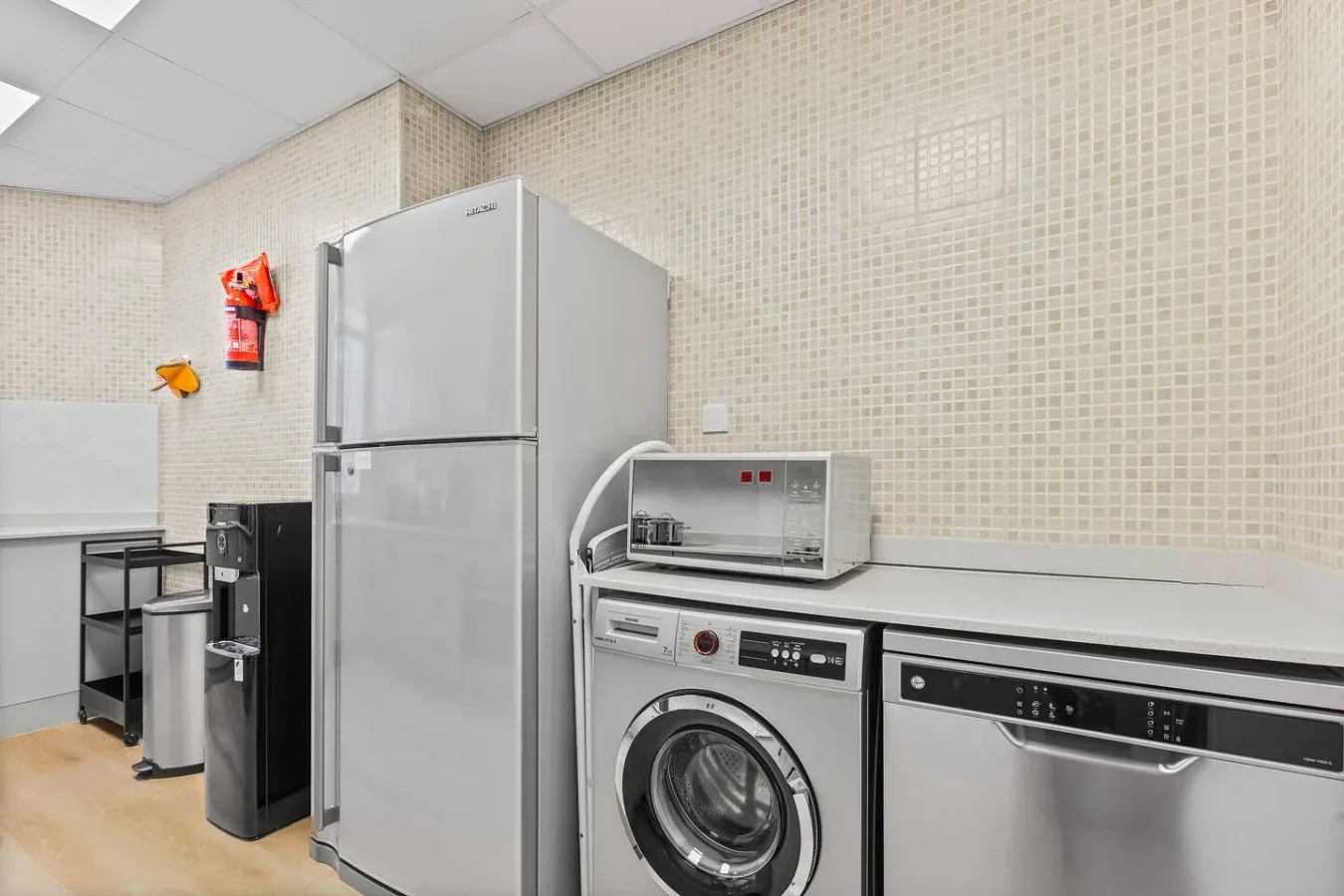 Un cuarto de lavandería con refrigerador, lavadora y secadora.