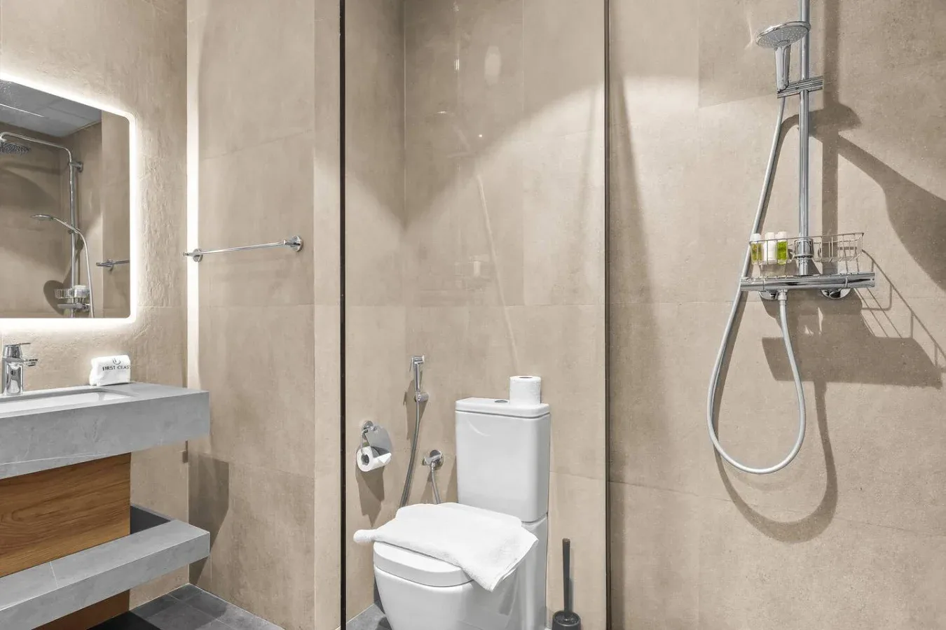 Un baño con azulejos, lavabo, inodoro y ducha de pared.