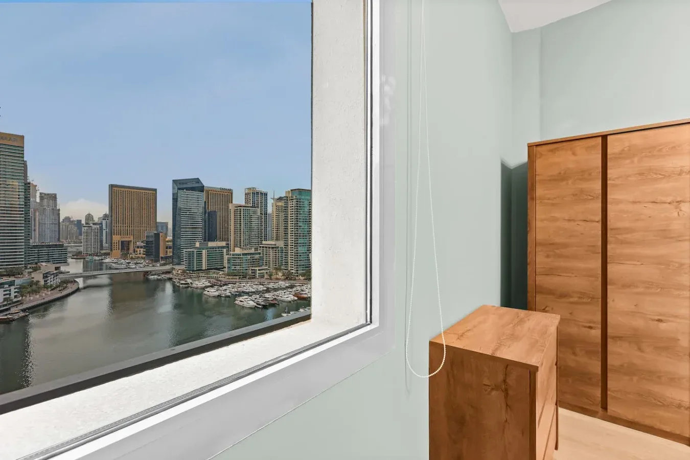 Una habitación con una gran ventana que da a un perfil urbano y al agua.