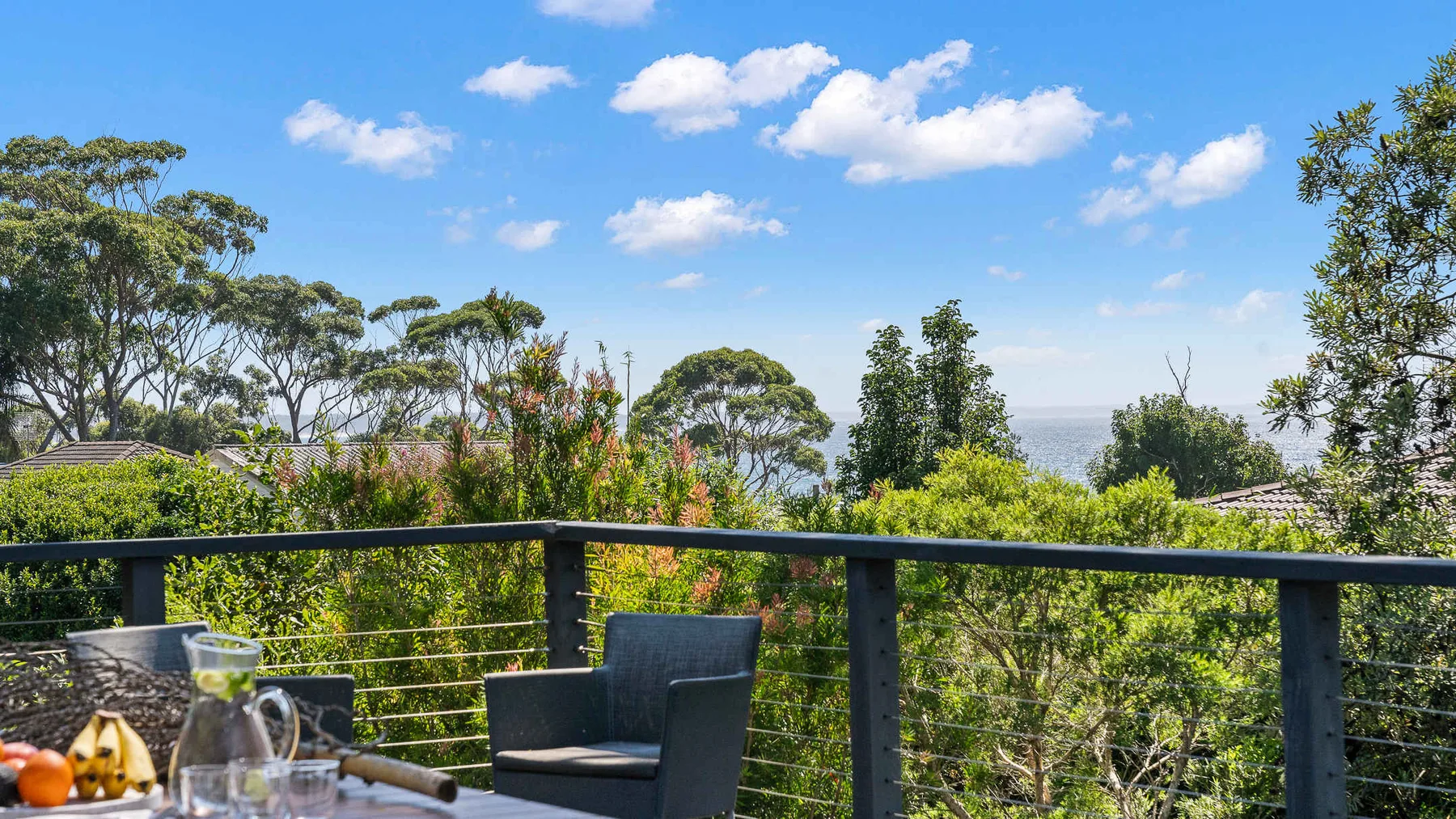 Una terraza ofrece vistas de las copas frondosas bajo un cielo azul despejado.