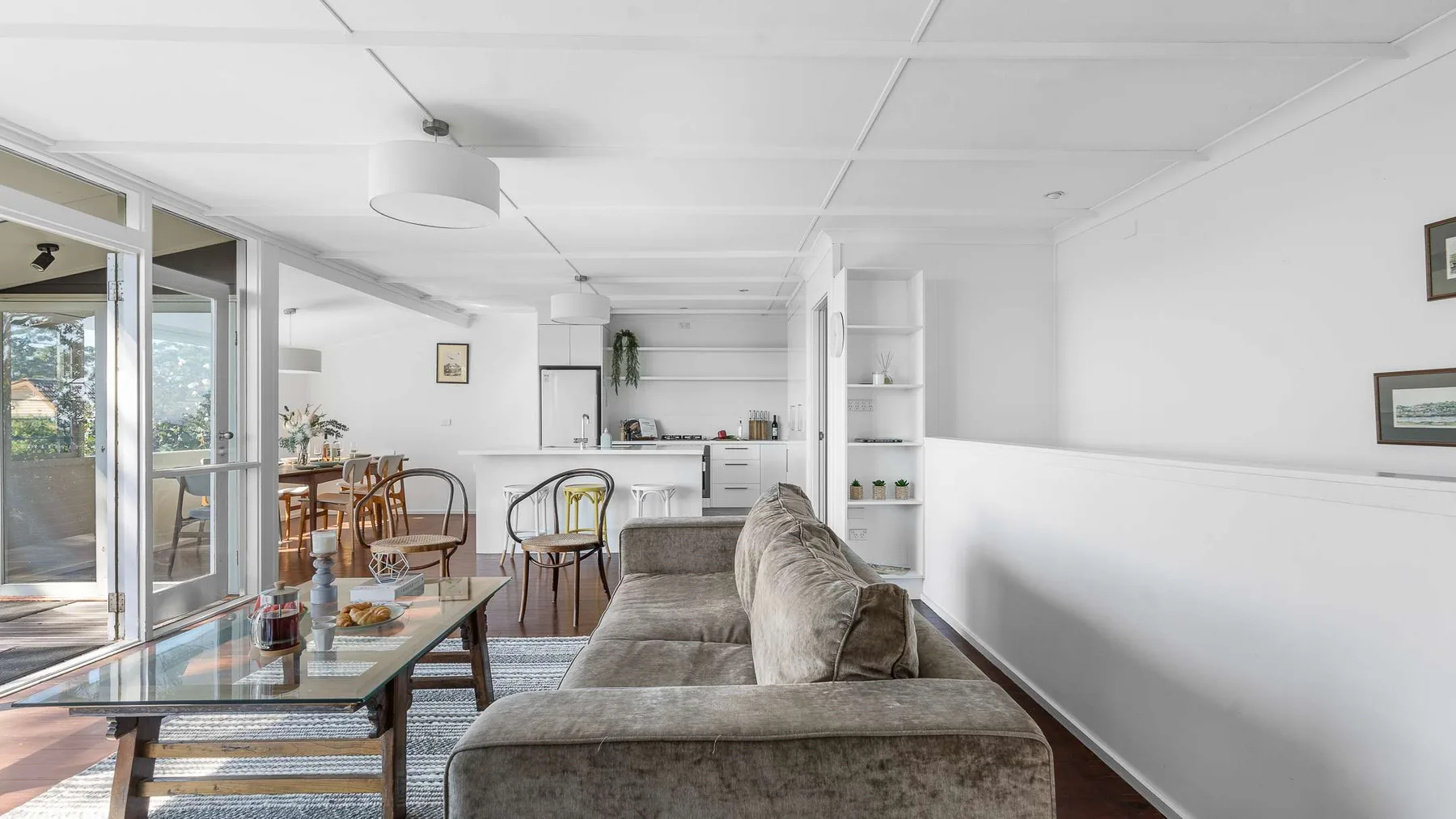 Una luminosa sala de estar y comedor con asientos, una mesa y cocina.
