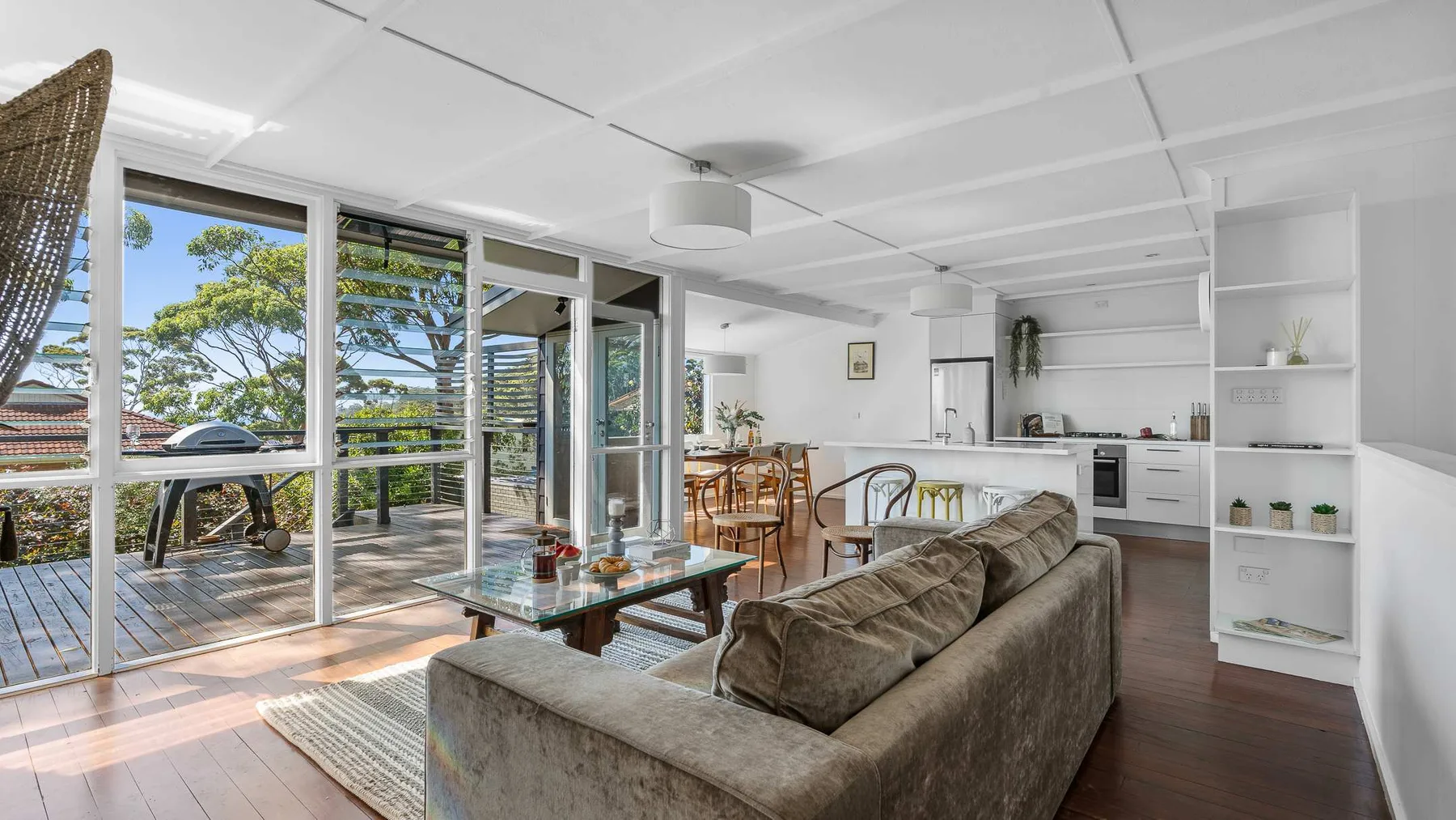 Open-plan living and dining area with seating beside large windows.