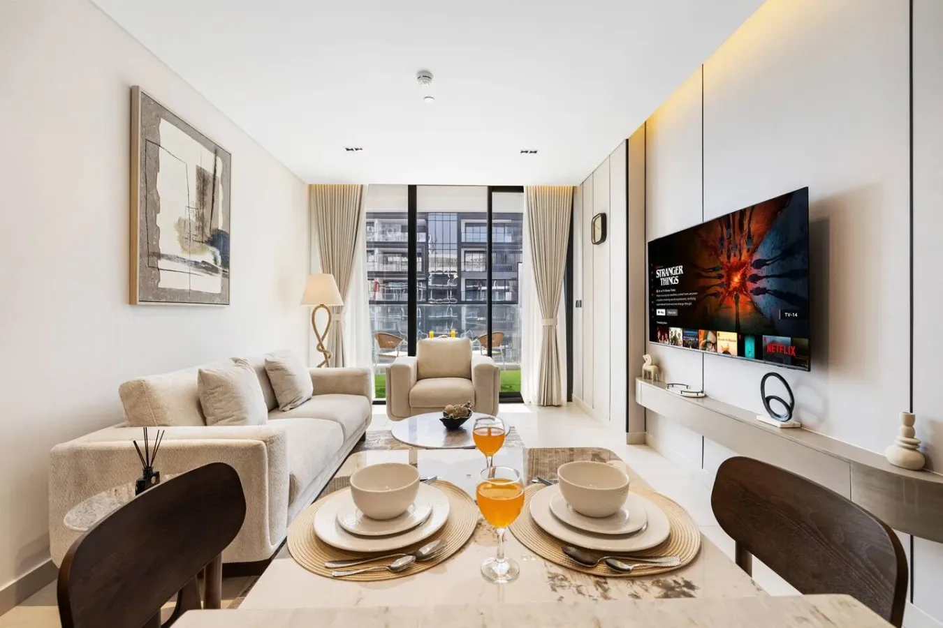 Una sala luminosa con asientos, una mesa de centro y un televisor.