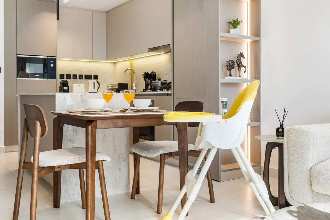 Un comedor con una mesa de madera está junto a una cocina moderna.