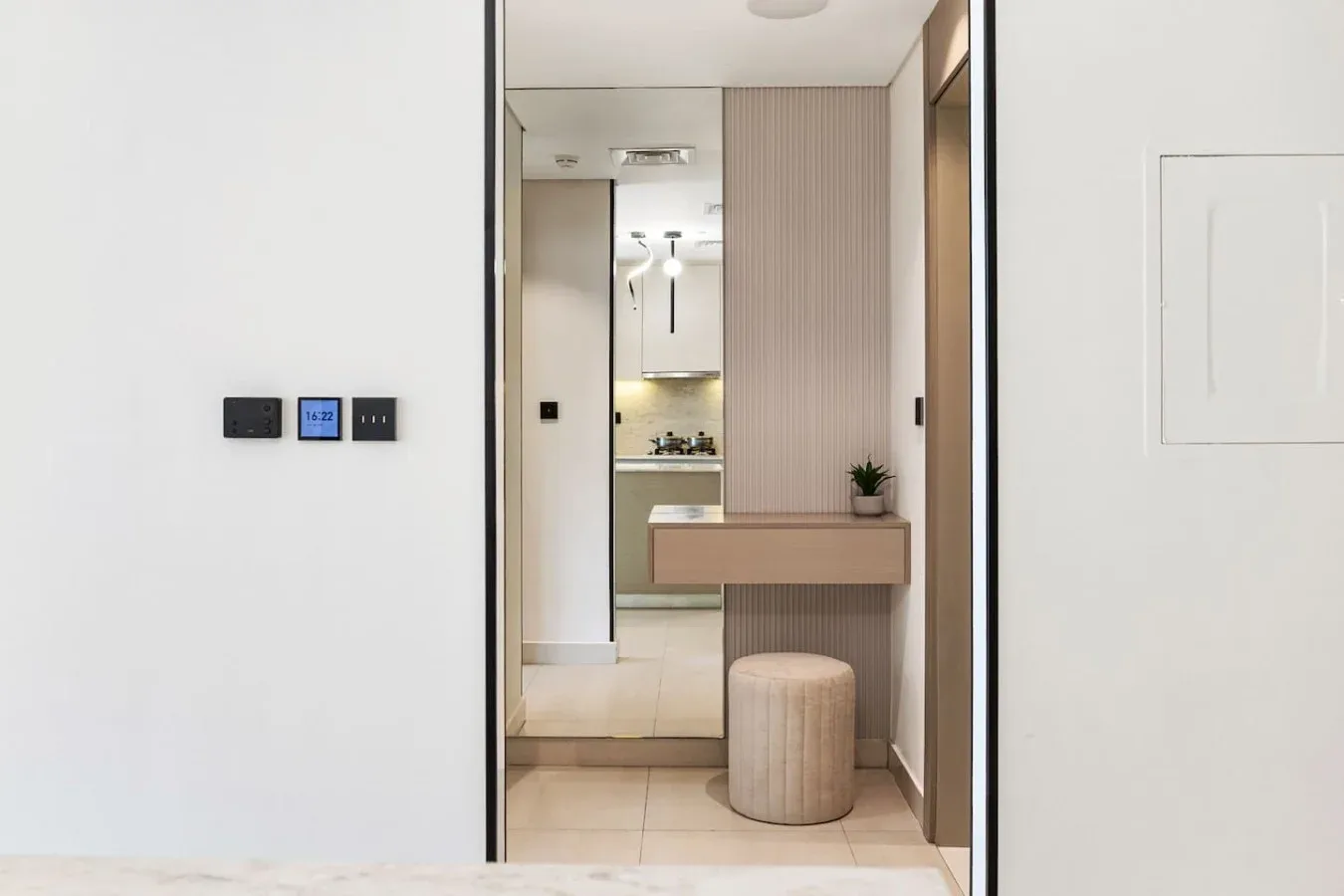 Una luminosa zona de lavabo con espejo y un pequeño taburete.