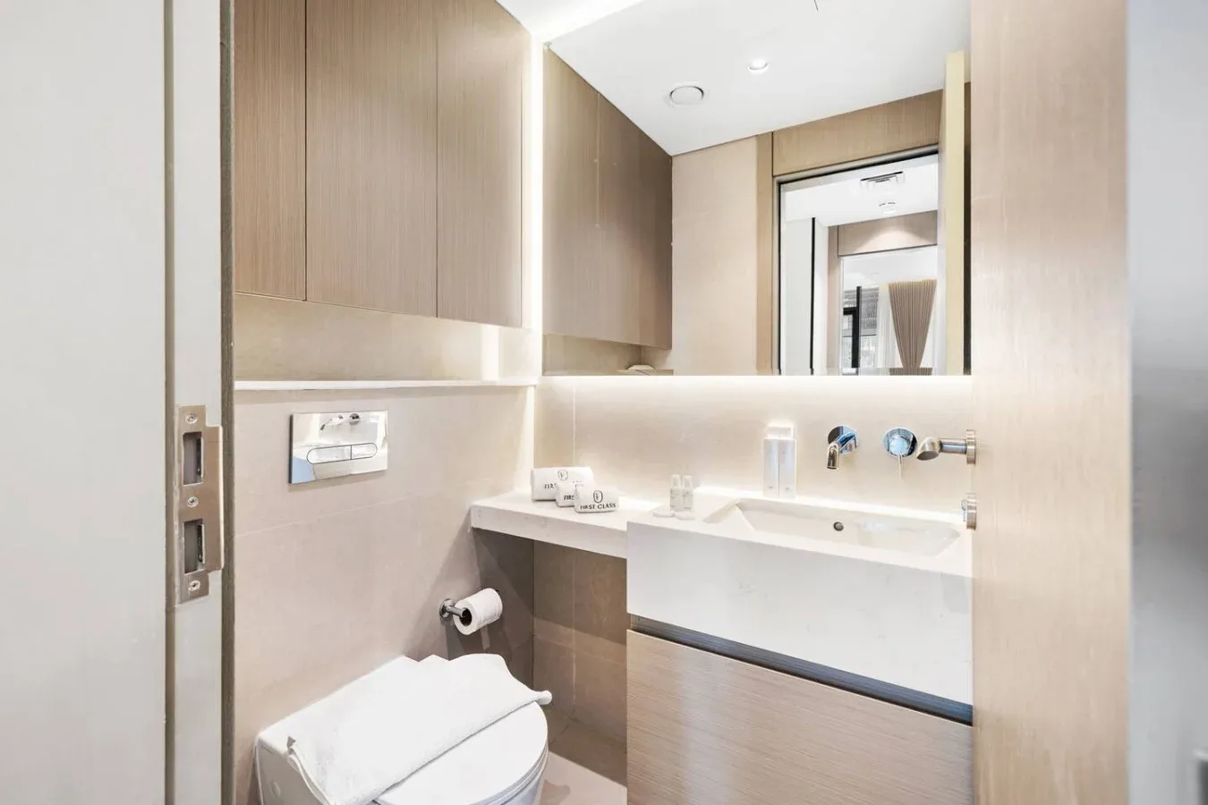 Un baño luminoso con lavabo, espejo e inodoro.
