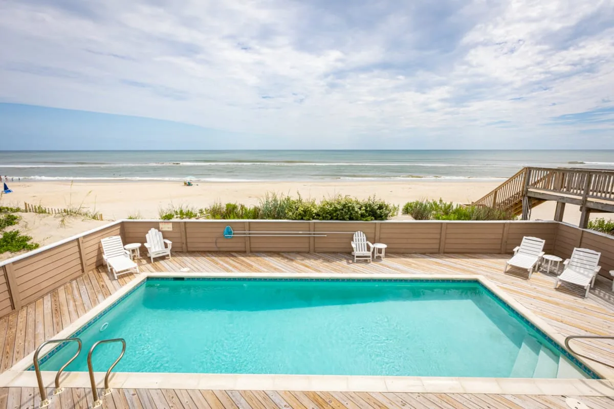 Una piscina y una terraza dan a la playa y al océano.