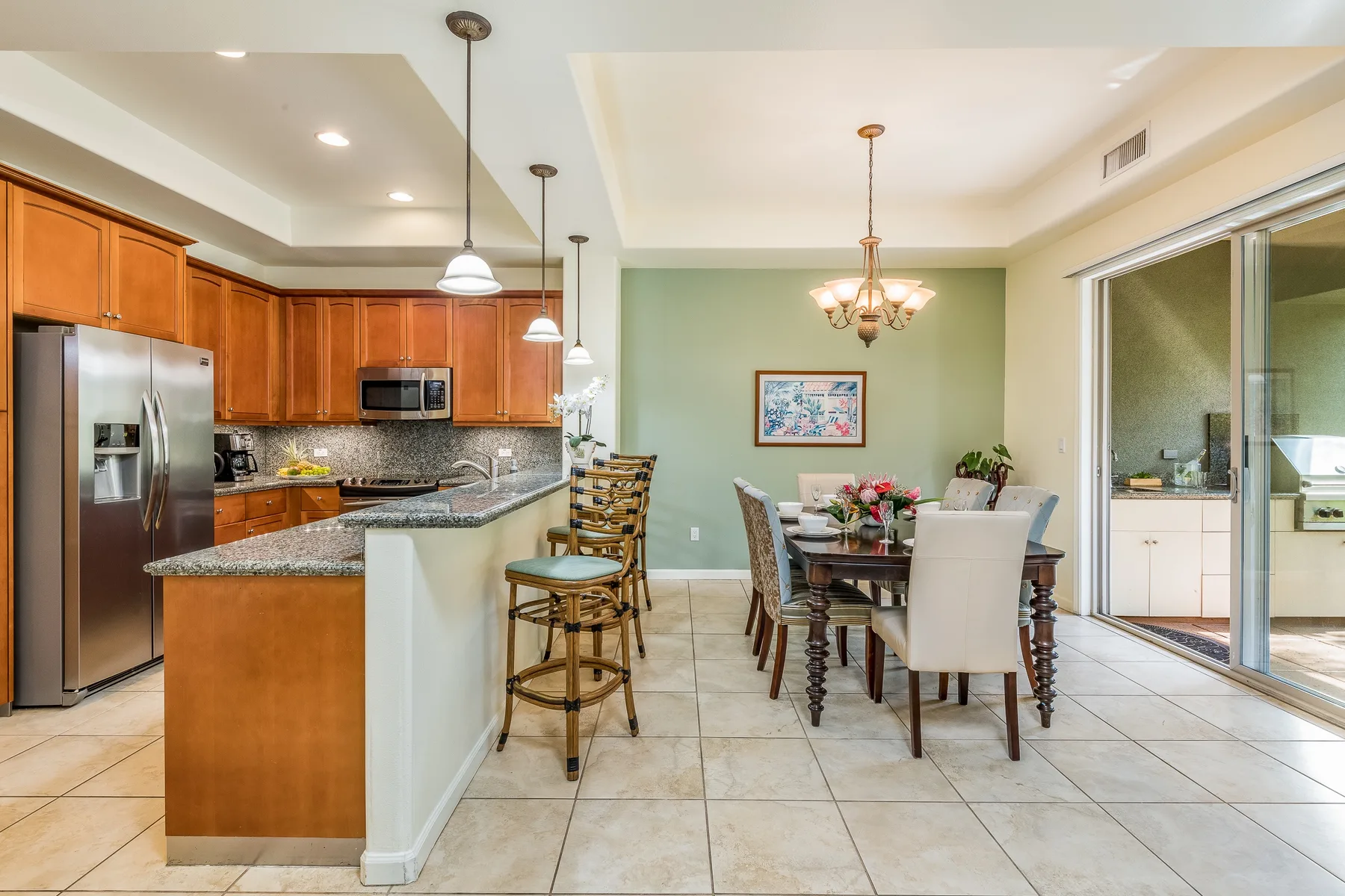 Cocina y comedor de planta abierta con barra y mesa de comedor.