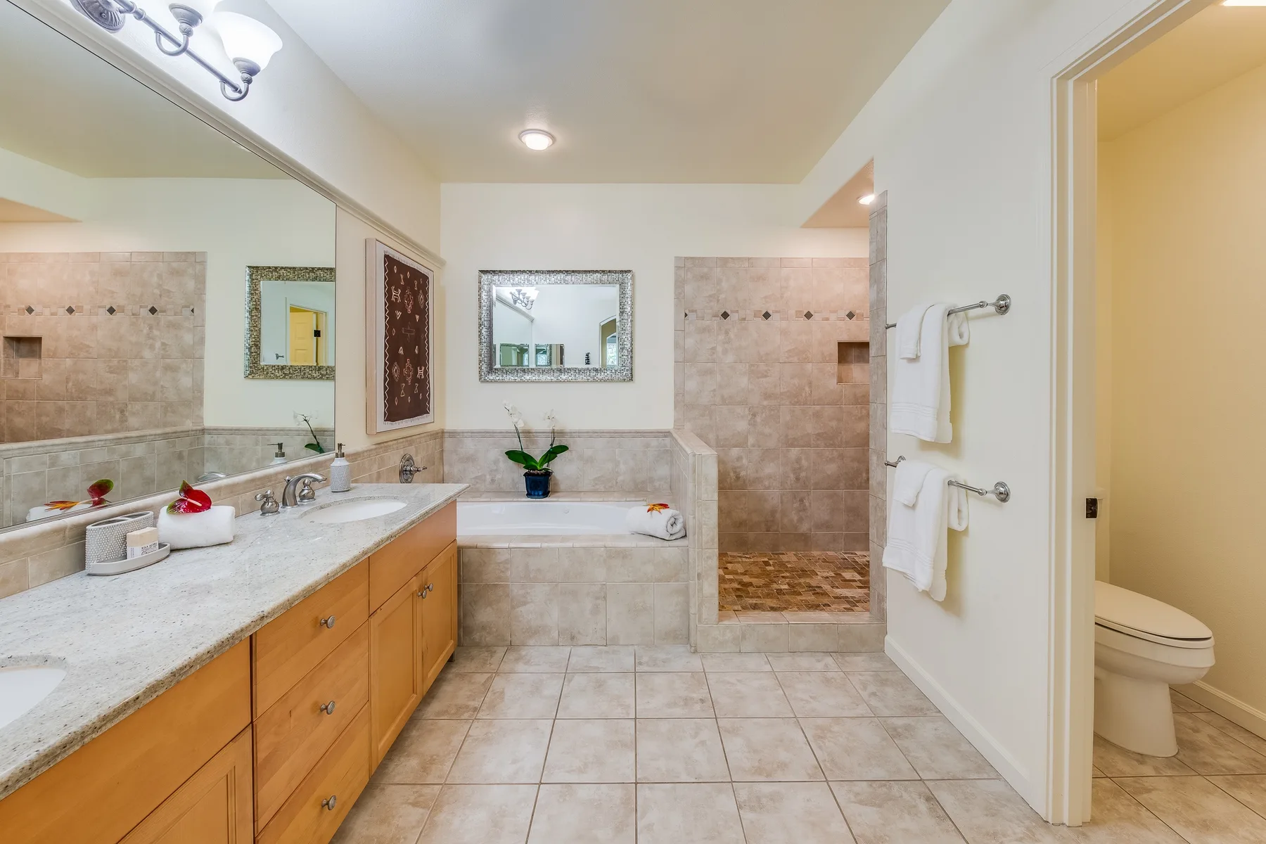 Un baño con azulejos, un tocador largo, una bañera y una zona de ducha.