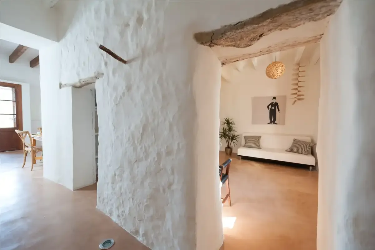 A bright interior hallway opens onto a sitting area with a bench and wall art.