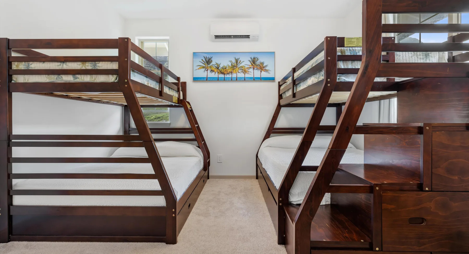 Un dormitorio con literas de madera y una imagen de palmeras en la pared.