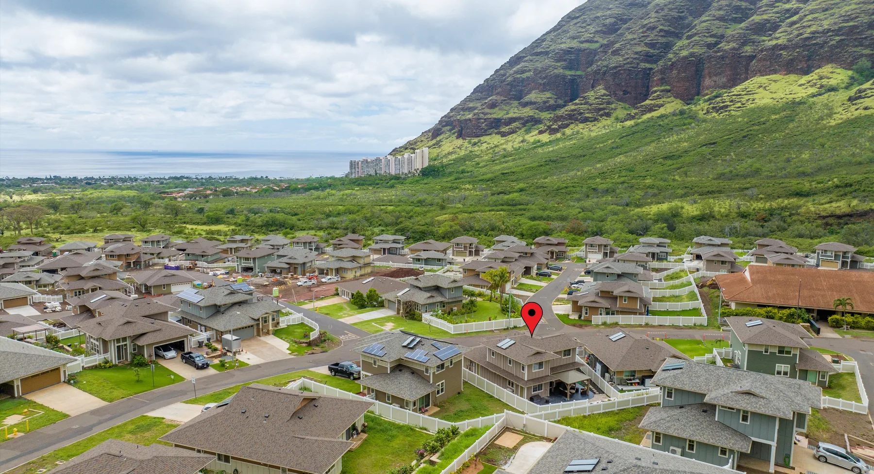 Vista aérea de un barrio residencial bajo una montaña verde.