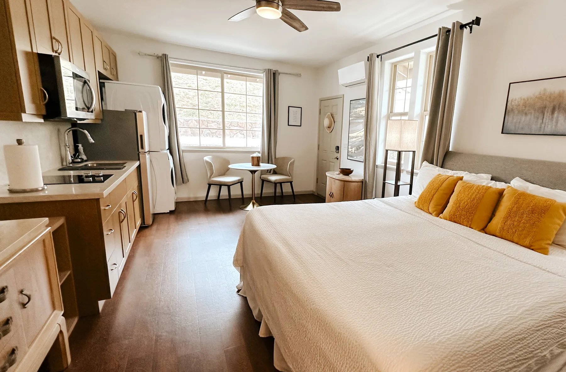 Un estudio luminoso combina una cama, una pequeña cocina y un comedor.
