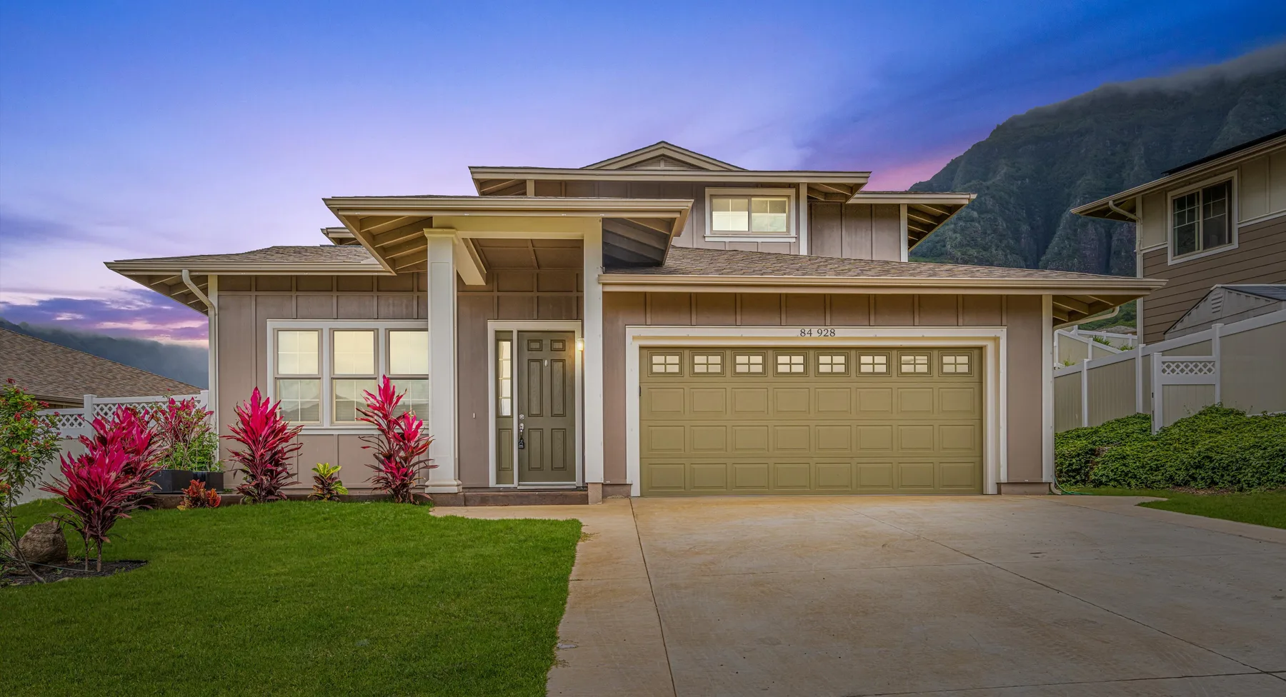 A modern two-story house with a garage, driveway, and front lawn.
