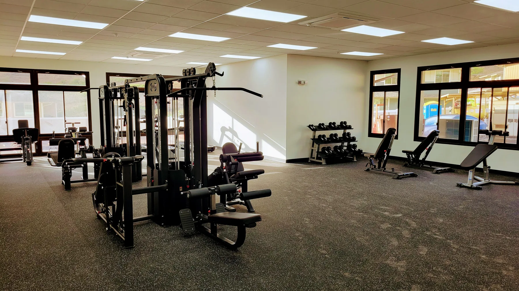 A spacious fitness room with exercise machines, weights, and treadmills.