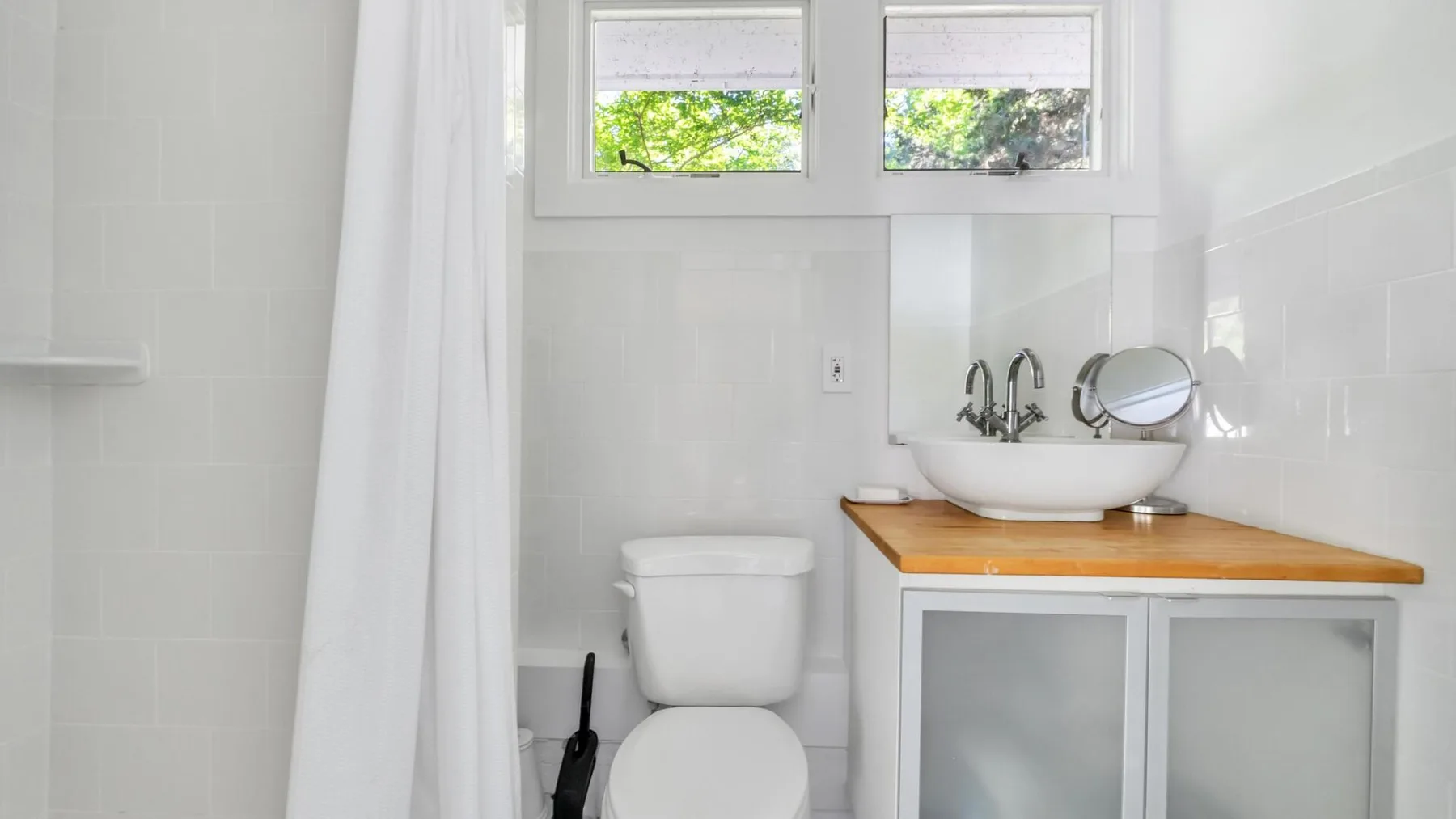 Un baño luminoso con lavabo, inodoro y cortina de ducha.