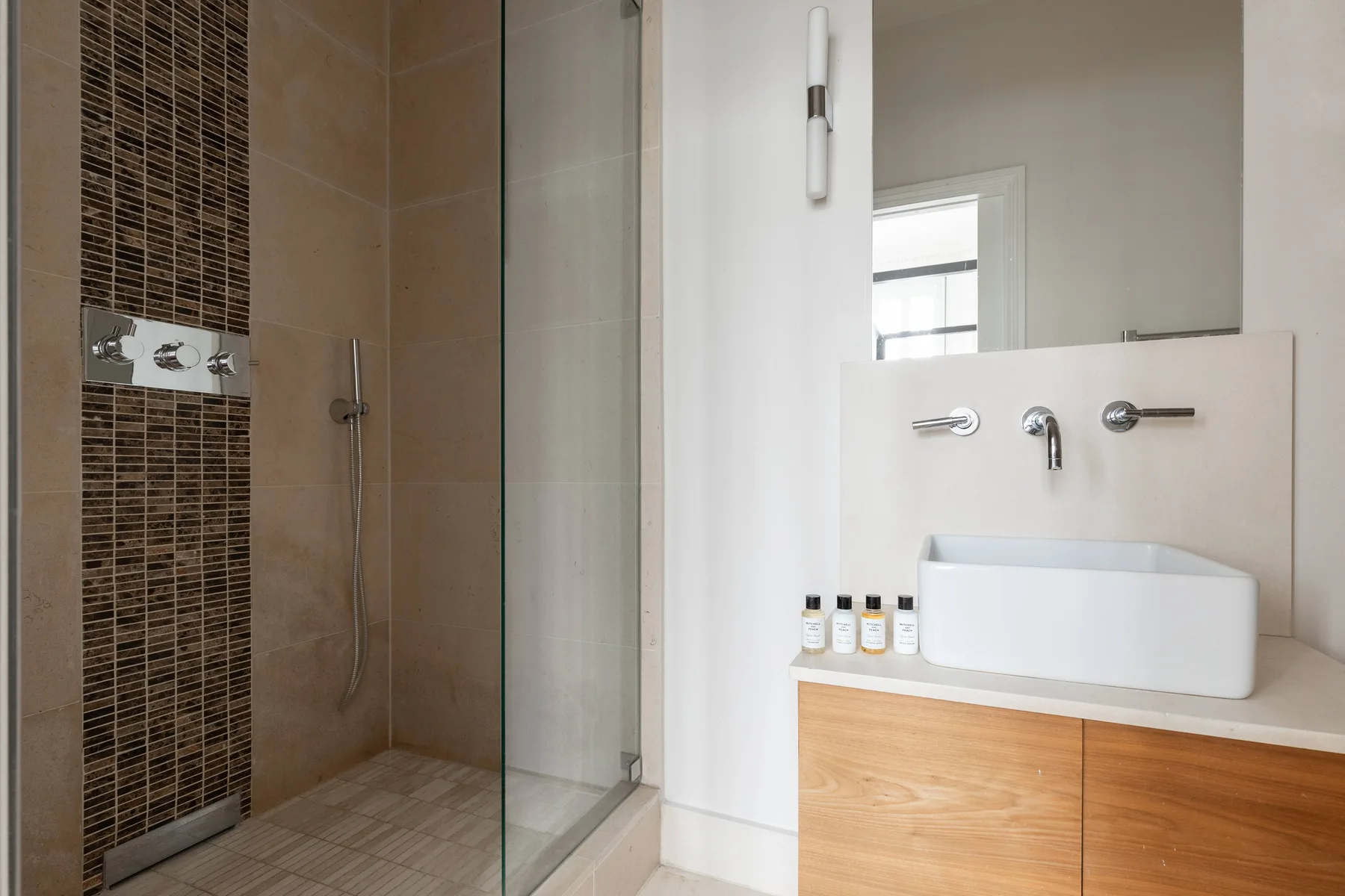 Un baño moderno con una ducha de vidrio y un lavabo sobre la encimera.