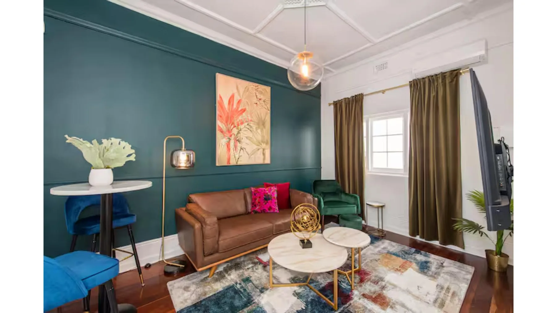 Una sala de estar con asientos, una mesa de centro y una ventana con cortinas.