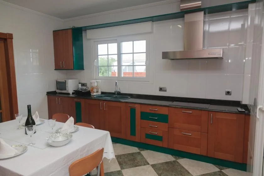 Una cocina con gabinetes de madera, una encimera y una ventana sobre el fregadero.