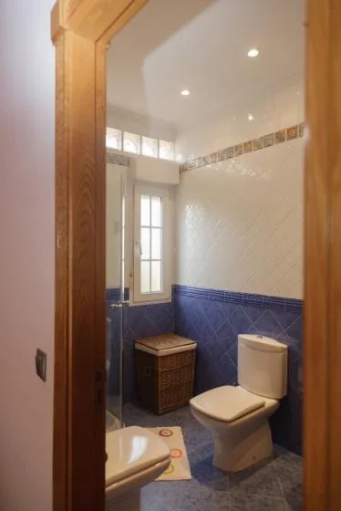 Un baño con inodoro, lavabo y una ventana pequeña.