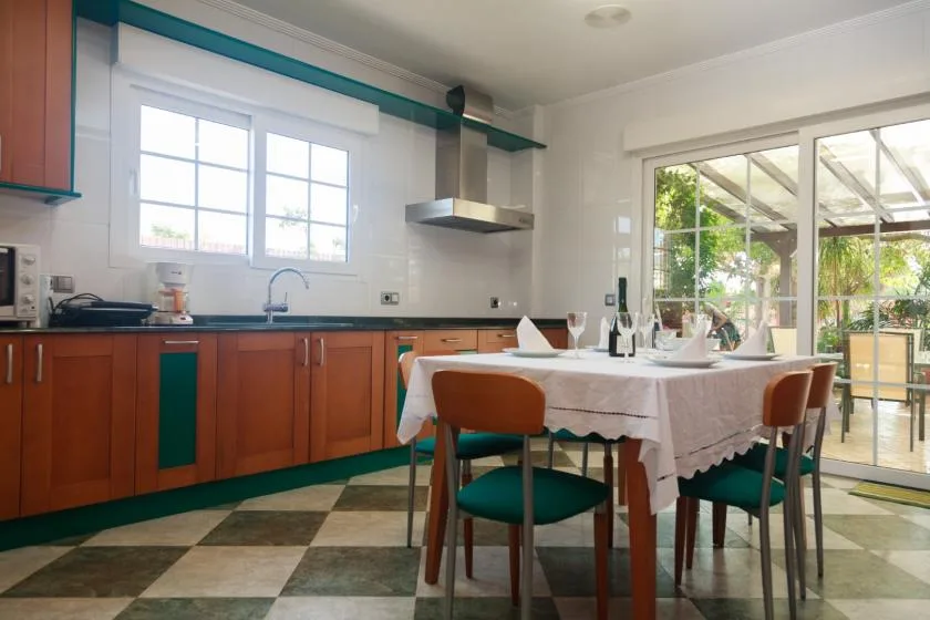 Una cocina y zona de comedor con una mesa junto a puertas corredizas de vidrio.