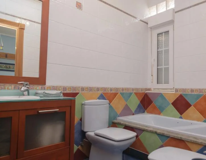 Un baño colorido con lavabo, inodoro y bañera.