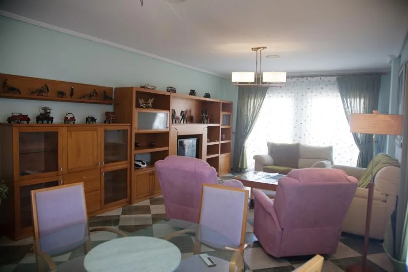 Una sala de estar con asientos alrededor de una mesa de centro y estanterías empotradas.