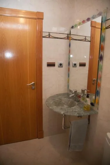 Un lavabo de baño con un fregadero redondo y un espejo de pared.