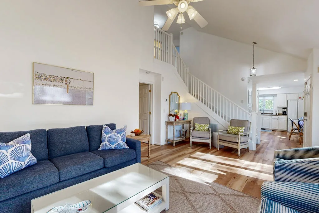 A living room with blue seating and a staircase leading to the upper level.