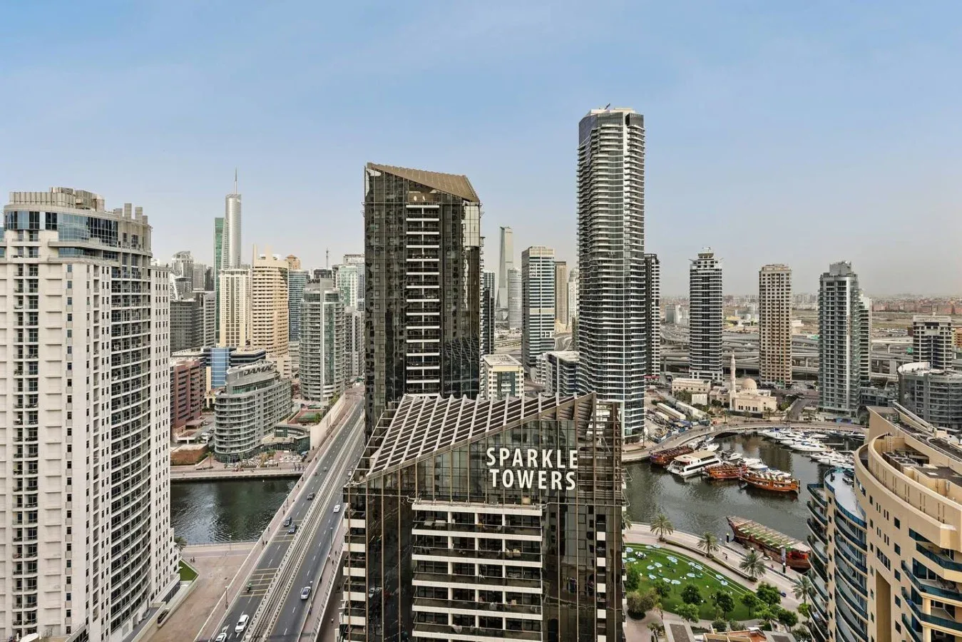 City skyline with high-rise buildings, a canal, and a bridge.