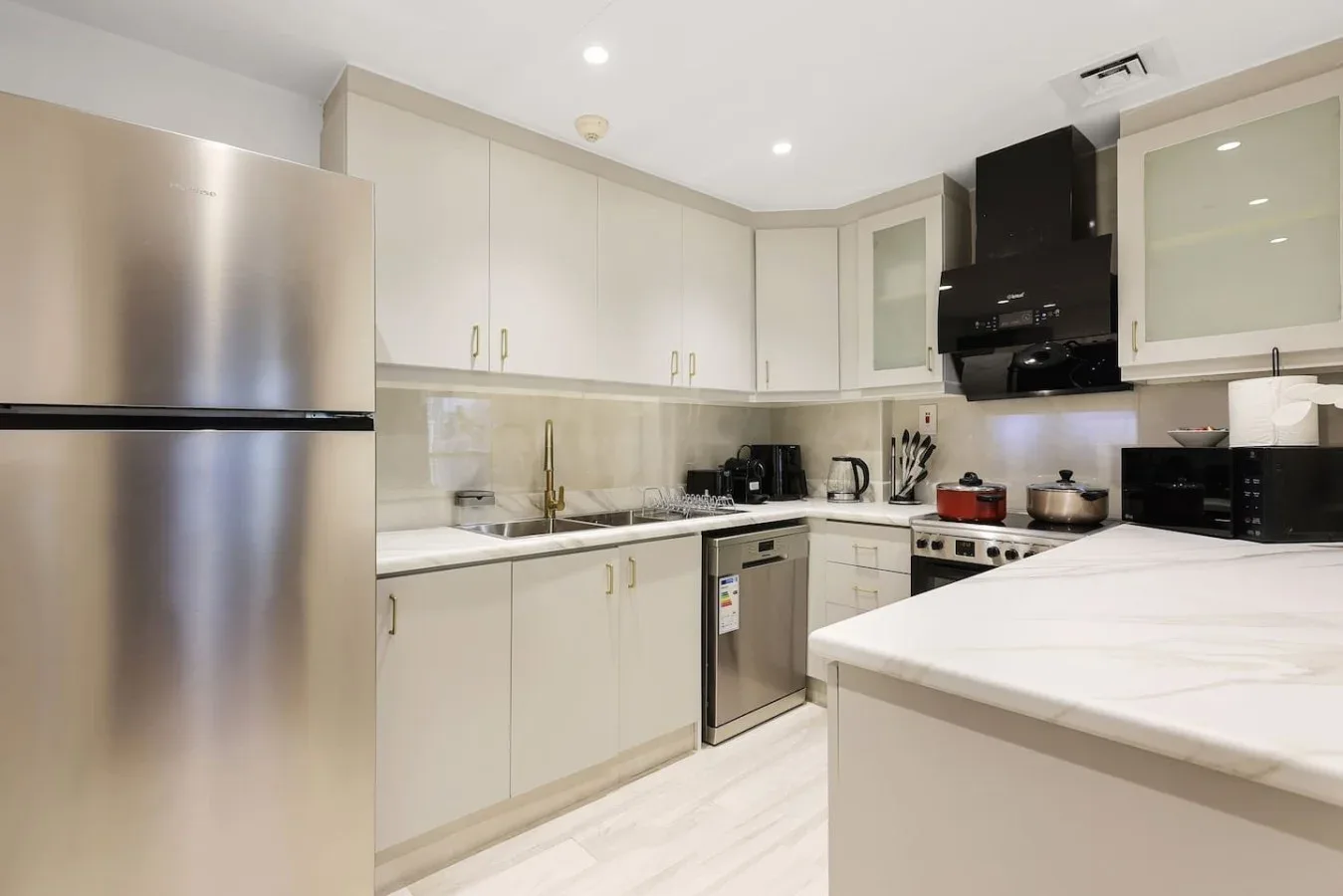 A bright kitchen with white cabinetry, stainless steel appliances, and a large island.