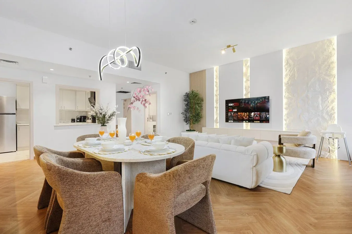 A bright open-plan living and dining area with a white sofa and dining table.