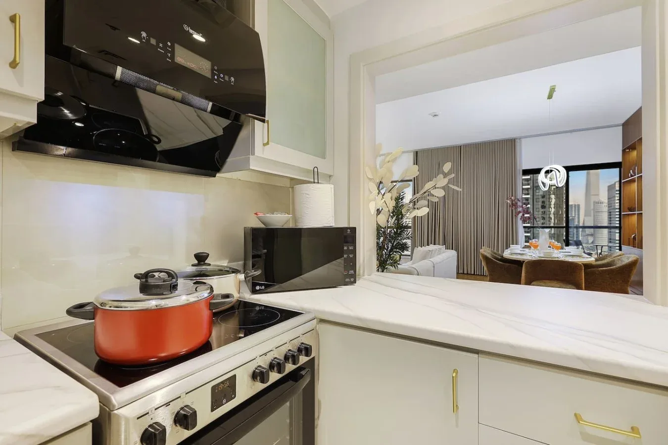 A kitchen with a pot on the stove, opening onto a dining area.