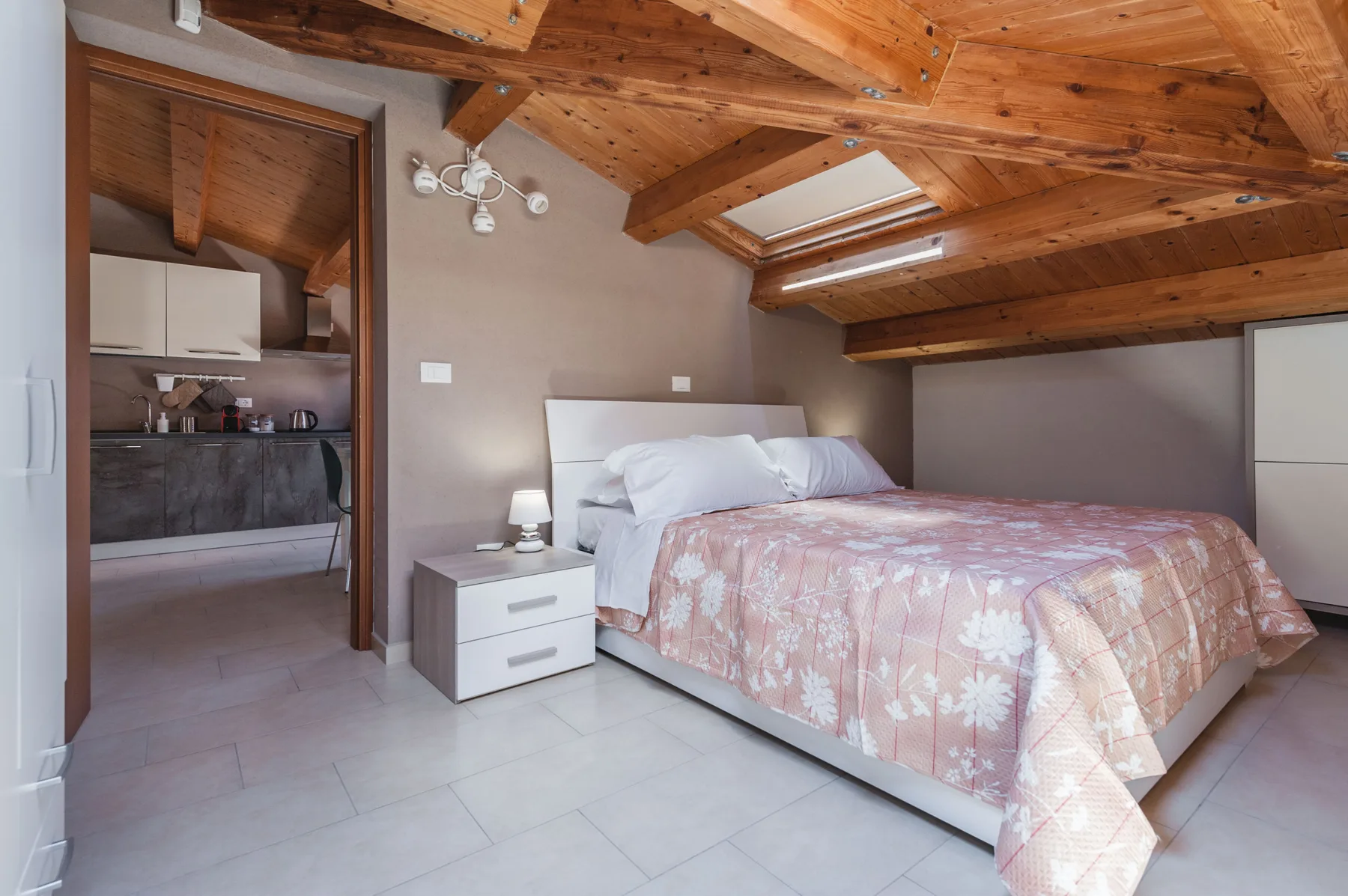 Un dormitorio con una cama y un techo de madera inclinado.