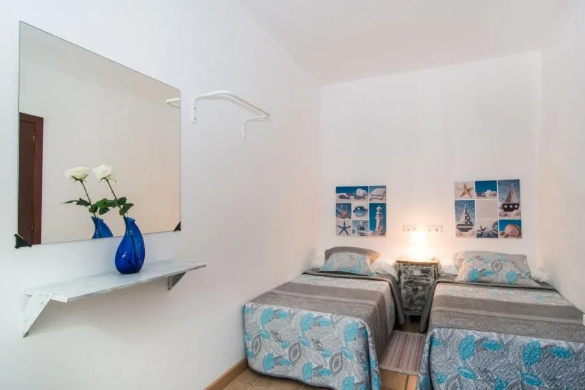 Un dormitorio con dos camas individuales y cuadros de temática marina en la pared.
