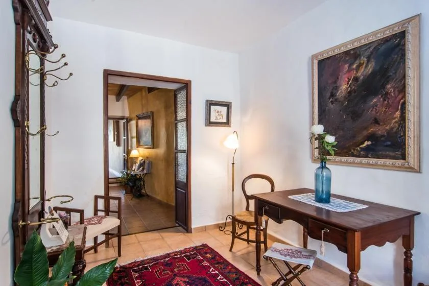 Una habitación amueblada con una mesa de madera, sillas y un cuadro grande enmarcado.