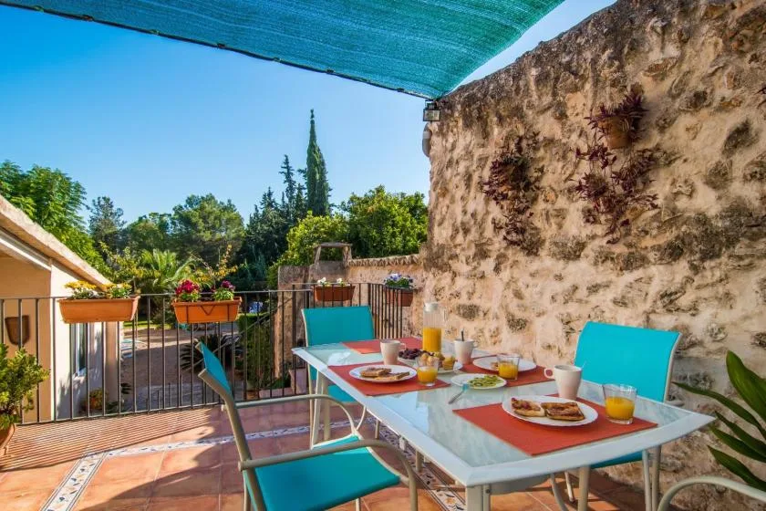 Comedor en una terraza al aire libre con una mesa bajo un toldo.
