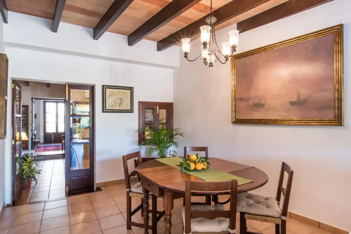 Comedor con una mesa de madera bajo vigas de techo vistas.
