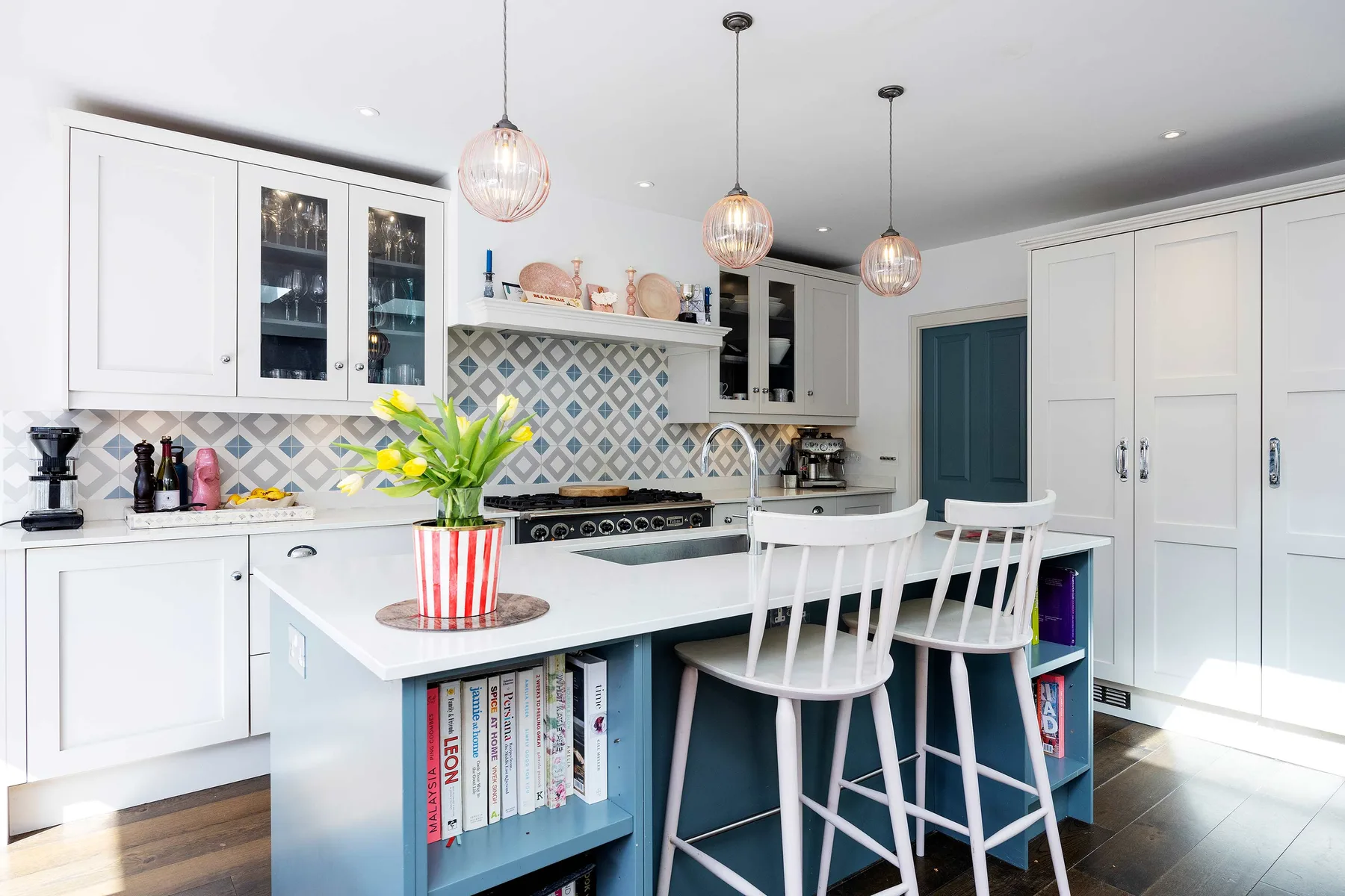 A bright kitchen with a central island and patterned backsplash.