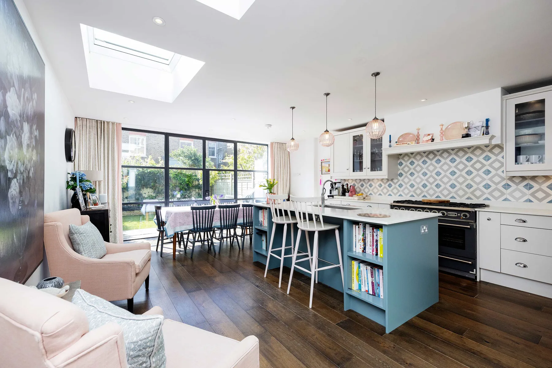 A bright open-plan kitchen and dining area with large windows and a central island.