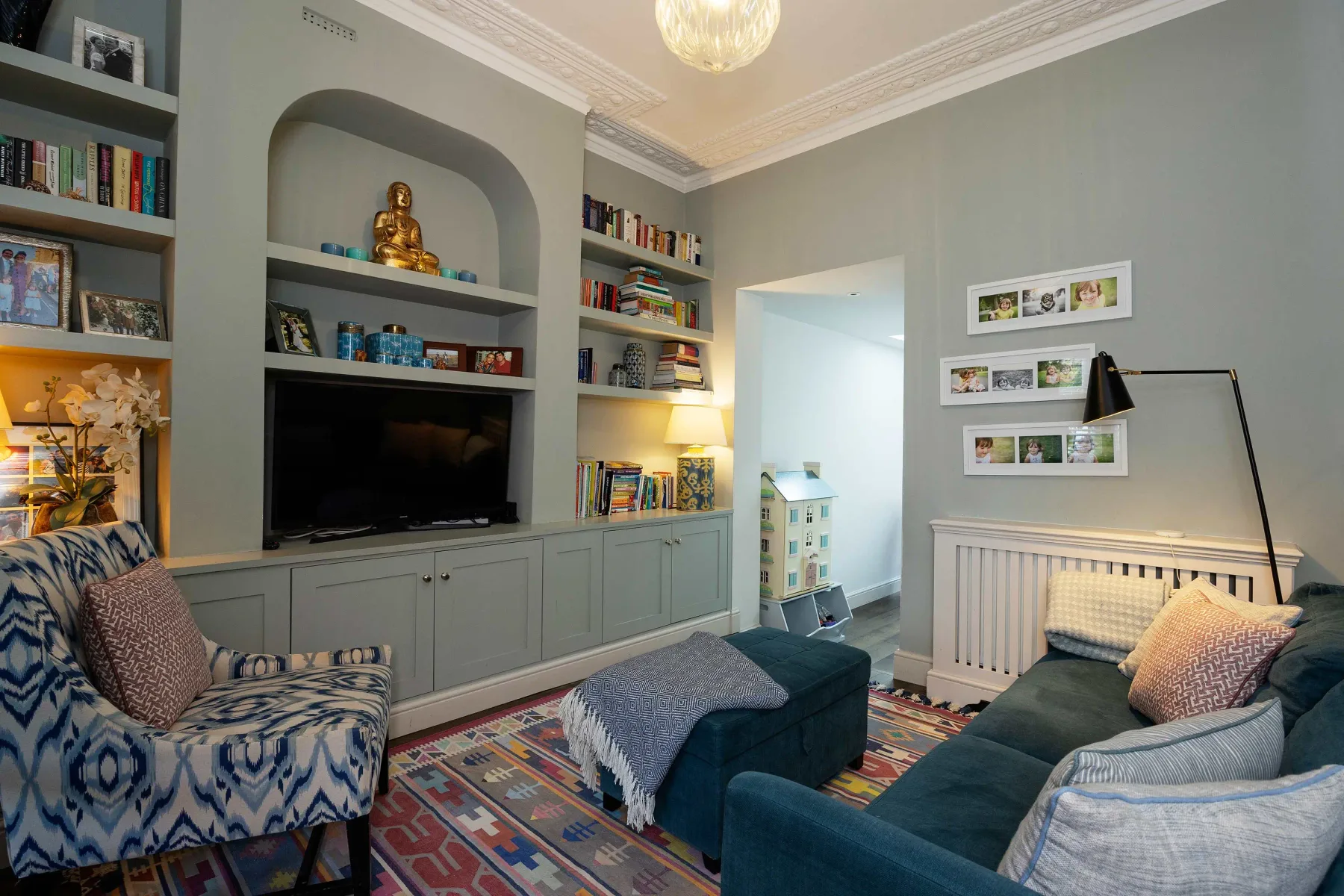 A living room with built-in shelves, a television, and seating.