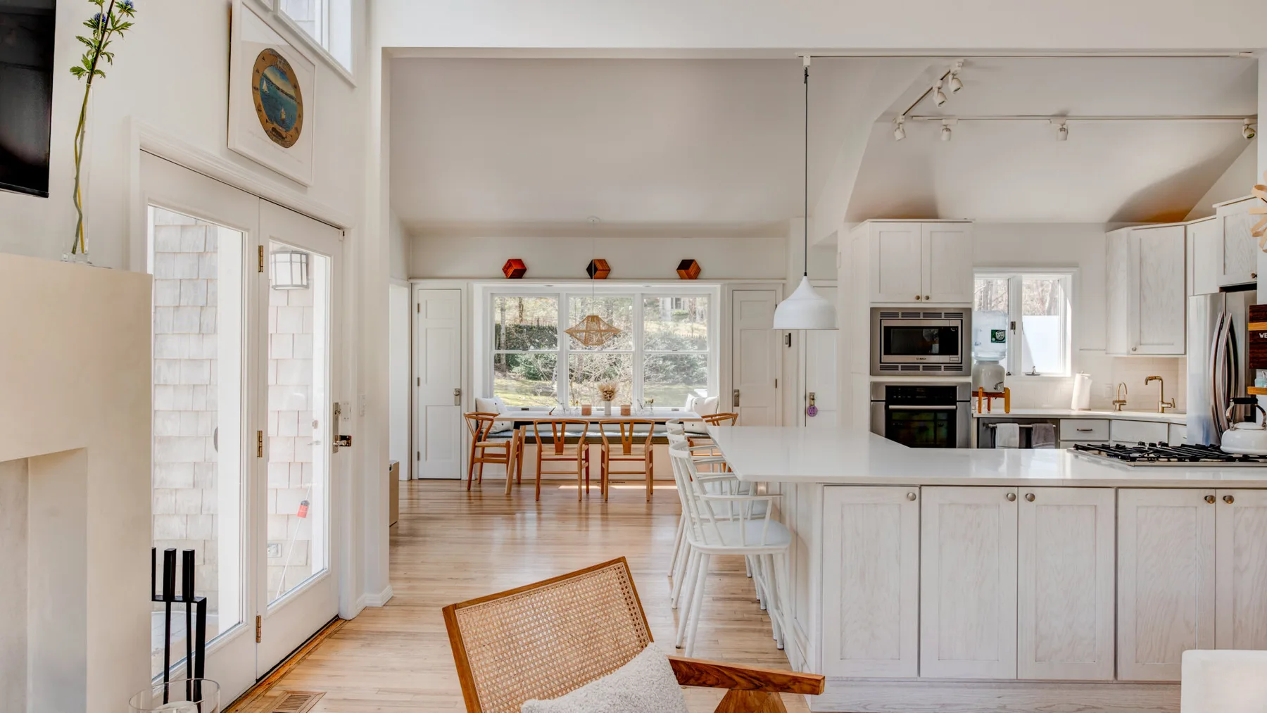Una luminosa cocina-comedor abierta con ventanas grandes y una isla central.