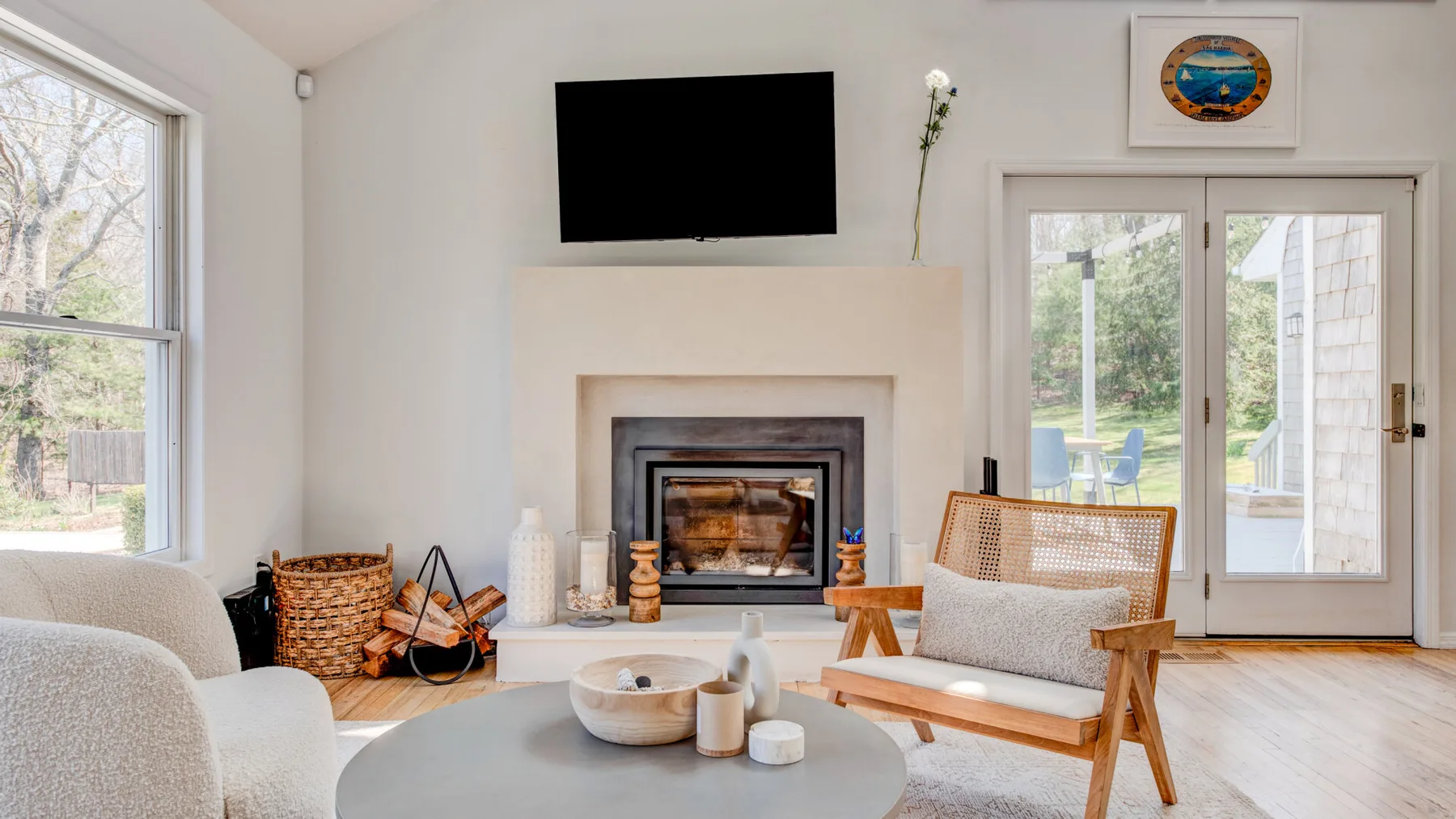 Una sala luminosa con chimenea, televisor y asientos.