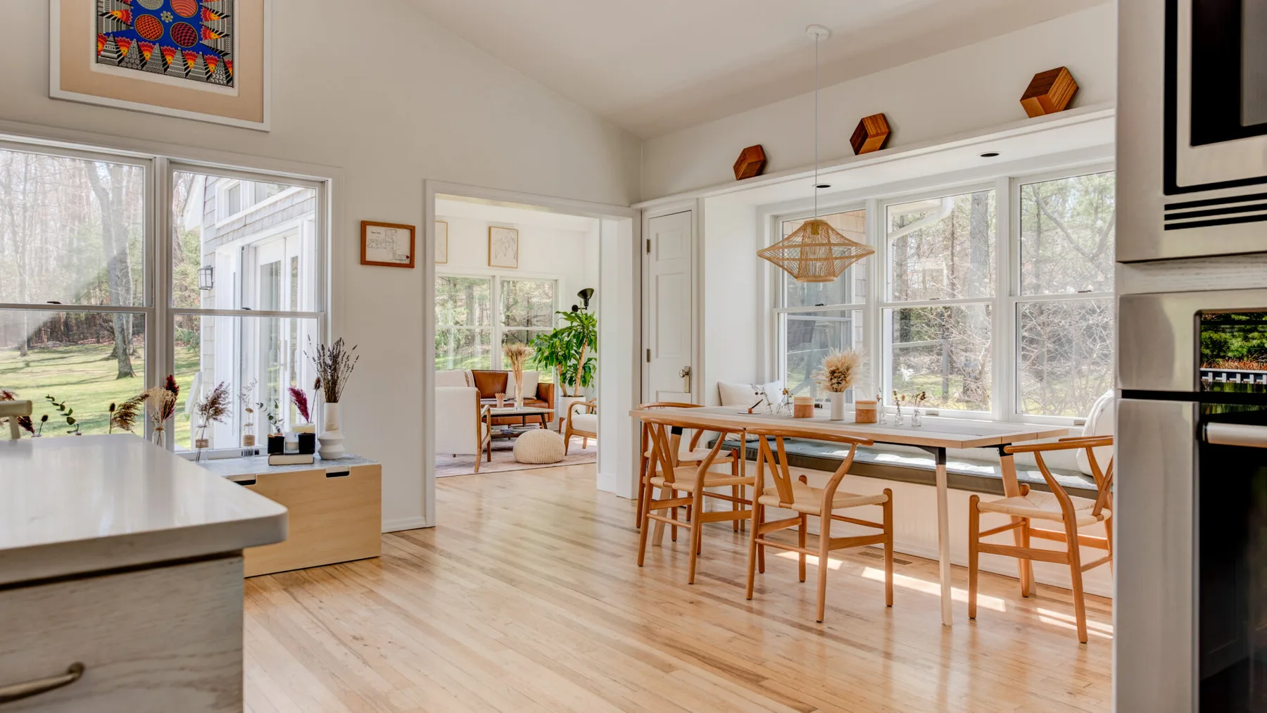 Un comedor luminoso con una mesa larga junto a grandes ventanas.
