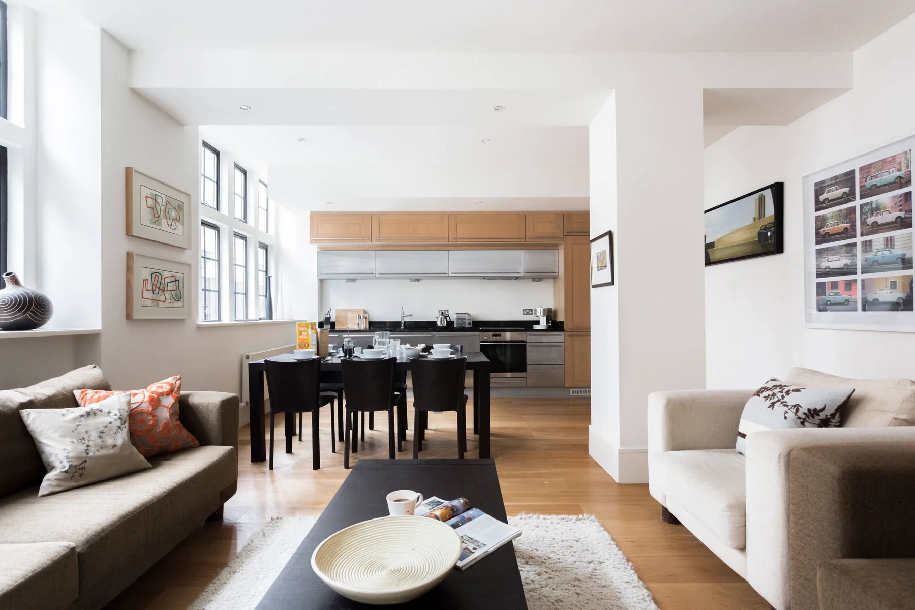 Una luminosa sala de estar y cocina de planta abierta, con asientos alrededor de una mesa de centro.