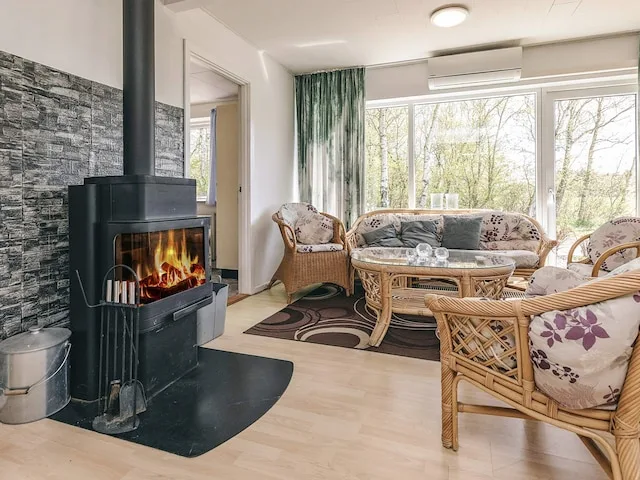 A bright living room with woven seating around a coffee table and a fireplace.