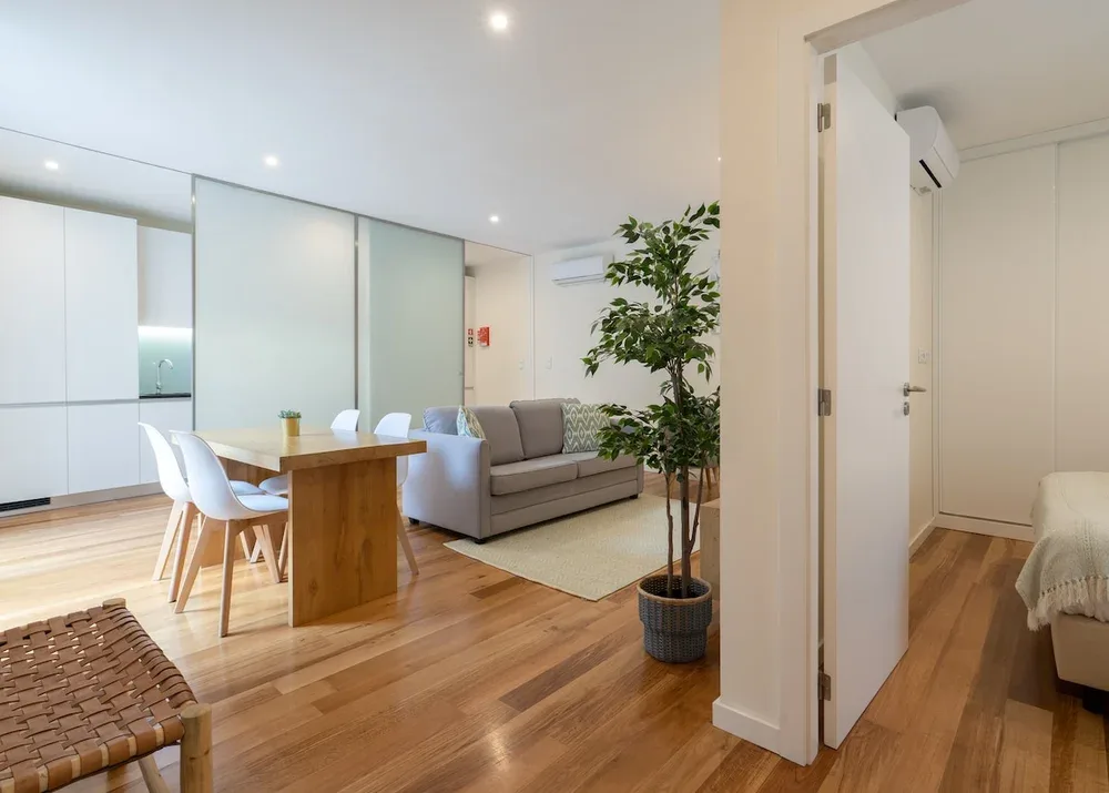 An open-plan living and dining area with a table, seating, and a potted plant.