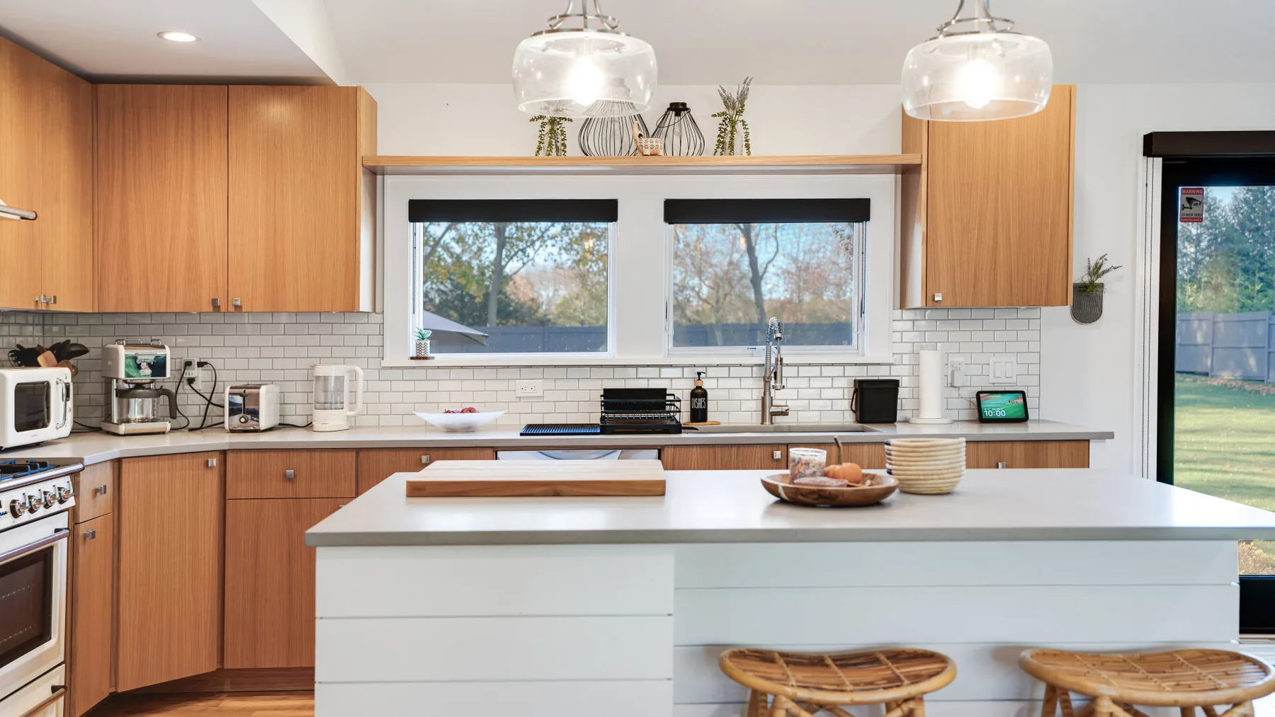 A bright kitchen with wood cabinets, a white island, and windows above the counter.