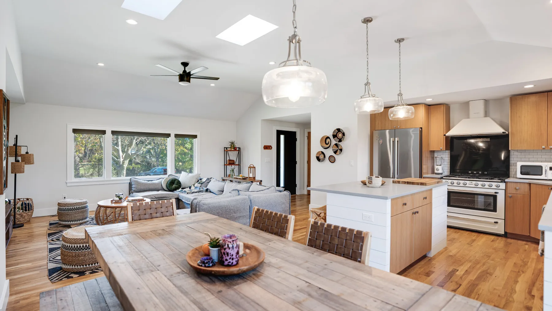 Cocina y sala de estar de concepto abierto con una mesa amplia y una isla.